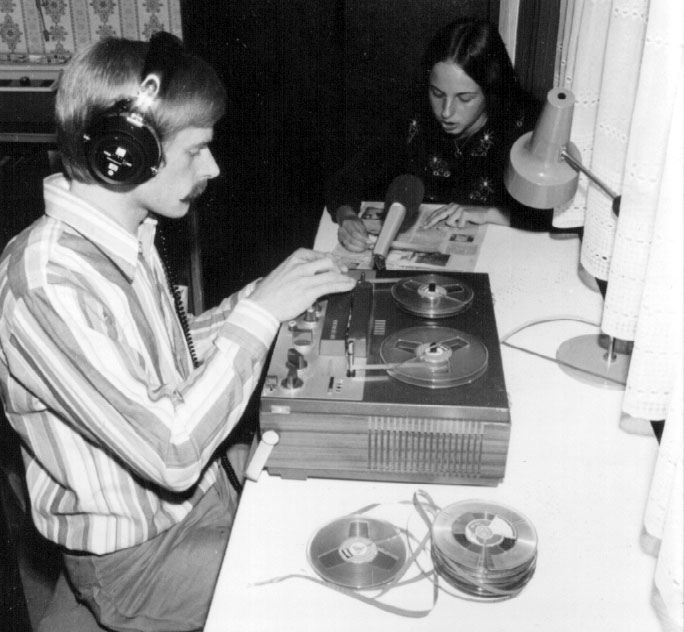 Schwarzweißbild von etwa 1978. Zwei junge Leute an einem Tonbandgerät